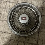 One 1981 To 1987 Oldsmobile Cutlass 14 Inch Wire Spoke Hubcap Wheel Cover. Fixed Price $25.00.